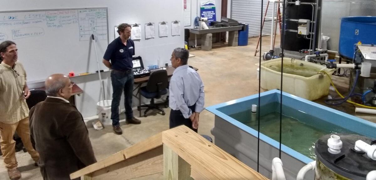 (Ashok Goel (bottom left) and Sandeep Kakar (right) tour North Georgia Technical College with Environmental Technology Instructors Duncan Hughes (right) and Kevin Peyton (left) Photo: AI-ALOE)